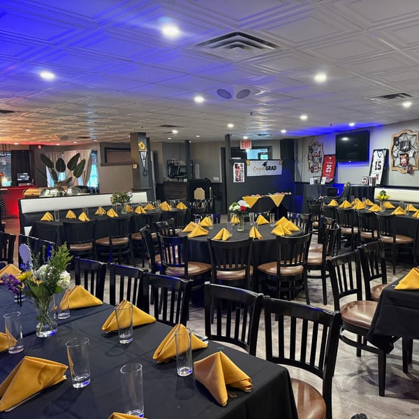 A Franco Martini Bar & Restaurant dining room set with black tablecloths, yellow napkins, and blue lighting.