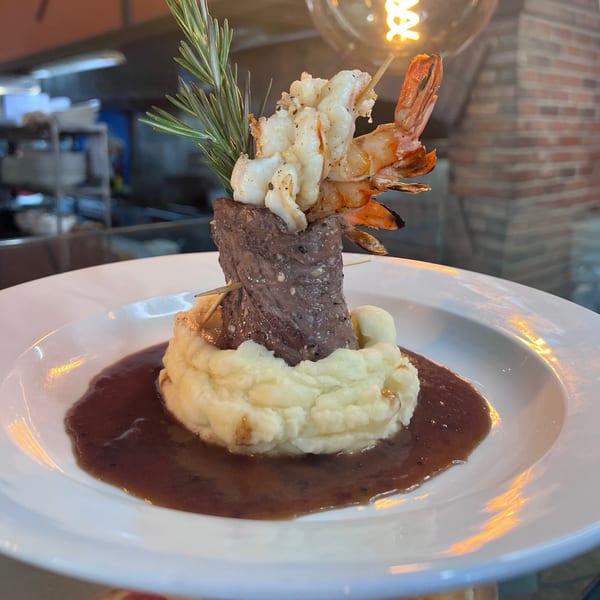 Franco Martini's Italian surf and turf, featuring steak, shrimp, mashed potatoes, and gravy.