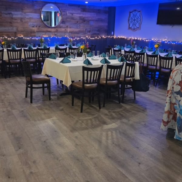 Dining room at Franco Martini Bar & Restaurant with tables set with white tablecloths and blue napkins.